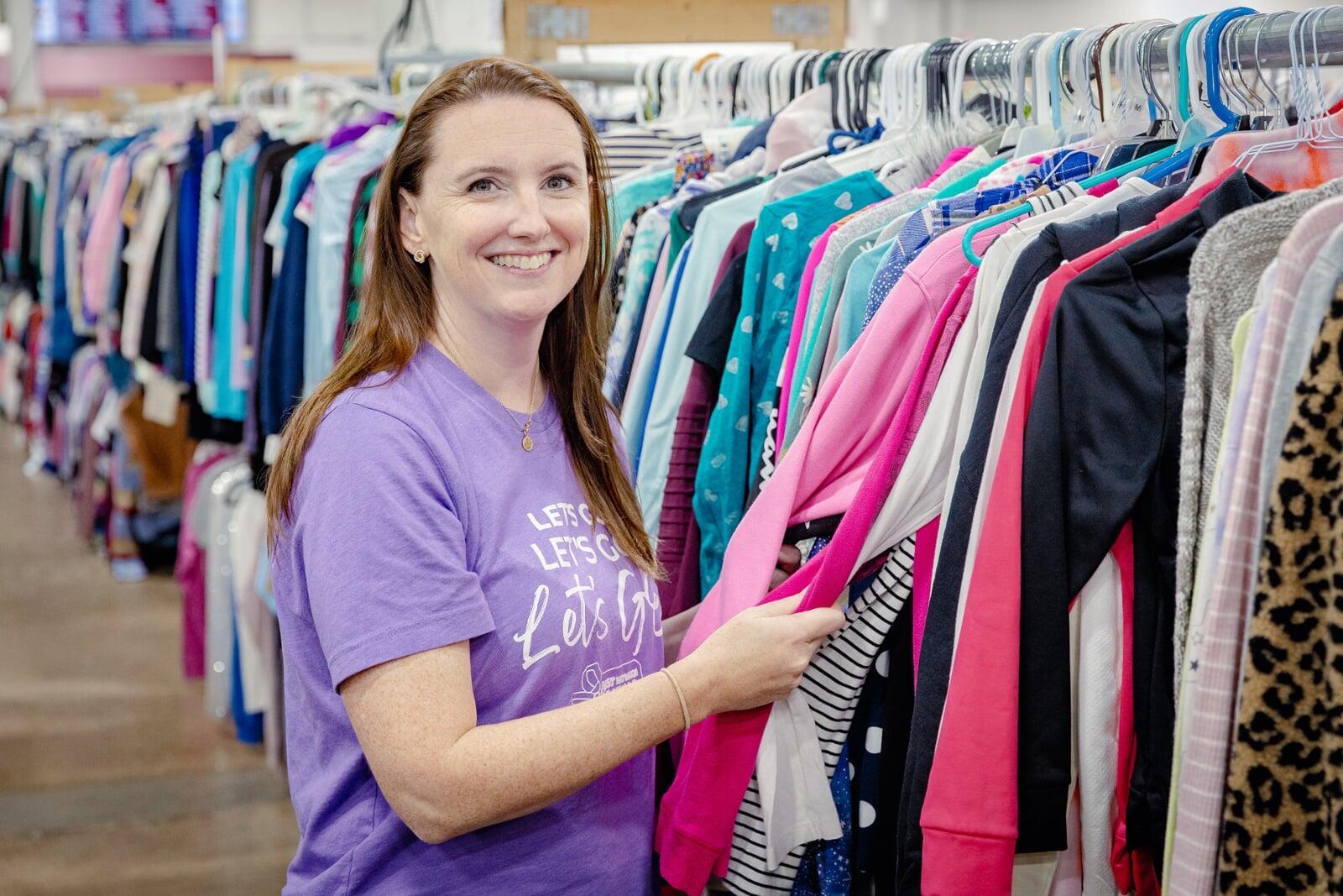 Mom and grandmother stand together, a few pieces of clothing in grandmom's hands, as they shop together for their family.