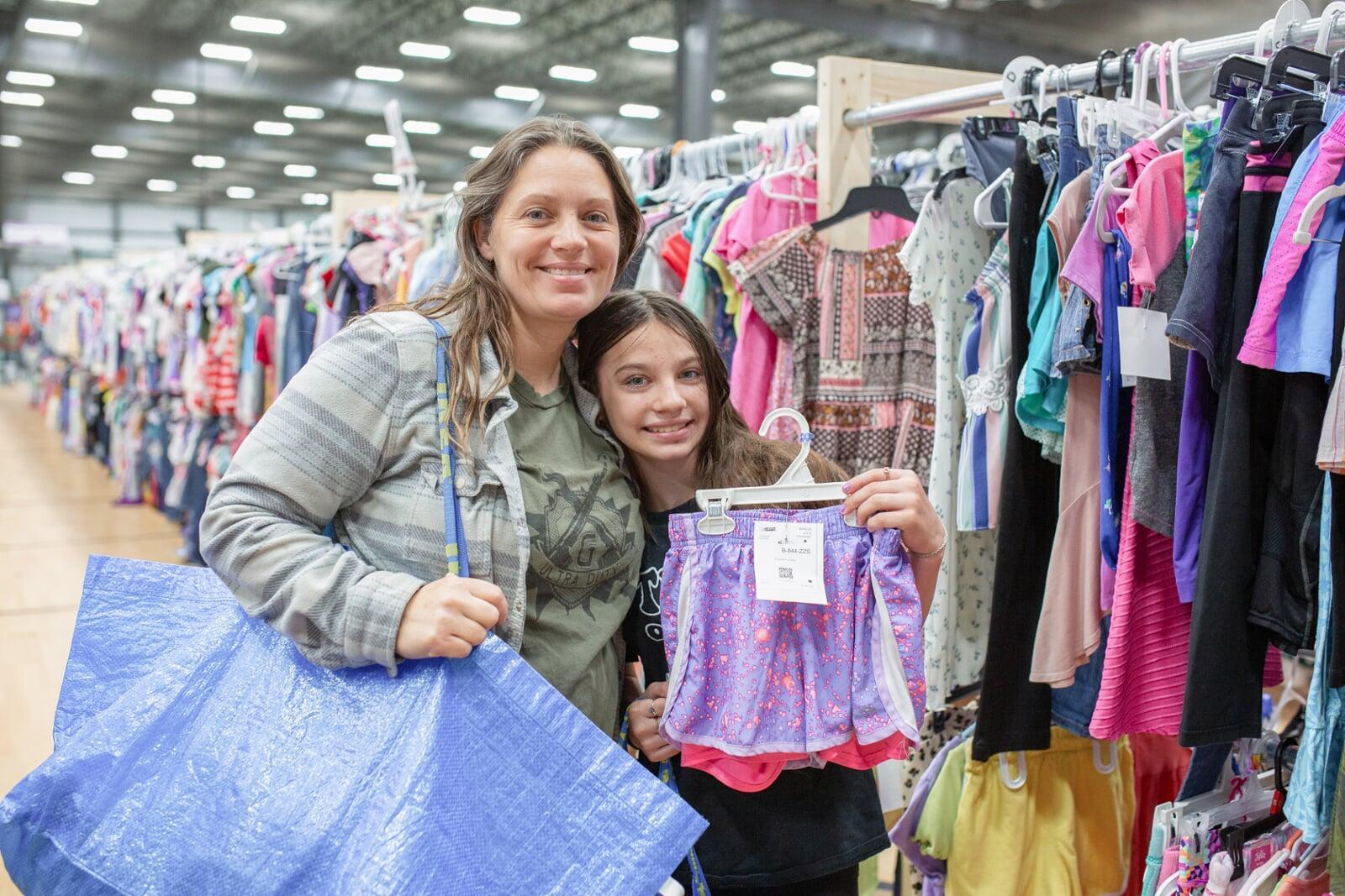 A mom, abuela and granddaughter attend a JBF sale in Dallas. Abuela is holding a babyseat.